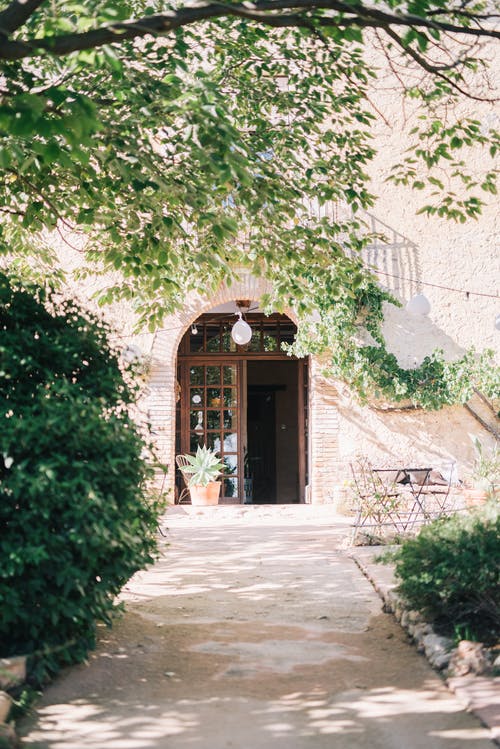 灰色的混凝土墙上的棕色木门 · 免费素材图片