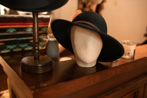 黑色软呢帽棕色木制的桌子上 · 免费素材图片