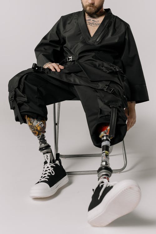 黑色皮夹克和黑色的裤子，坐在椅子上的人 · 免费素材图片