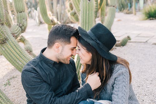 黑帽子的男人亲吻女人的灰色毛衣 · 免费素材图片