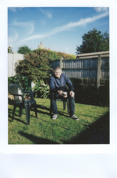 男子坐在椅子上拿着茶杯的照片 · 免费素材图片