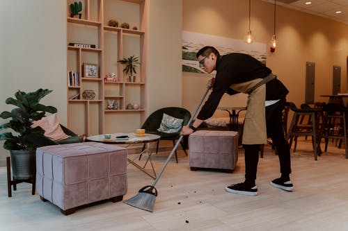 黑色长袖衬衫和棕色的裙子，拿着扫帚的女人 · 免费素材图片