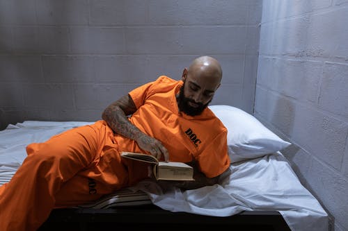 躺在床上的橙色长袖衬衫的男人 · 免费素材图片