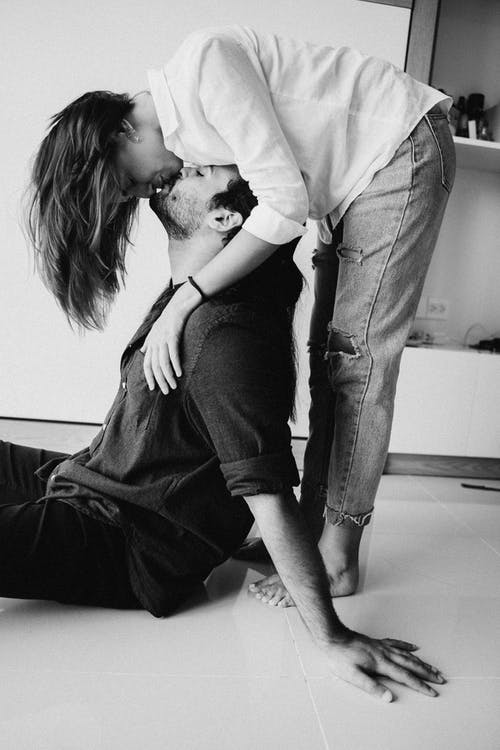 灰色西装的男人亲吻穿着黑裙子的女人 · 免费素材图片