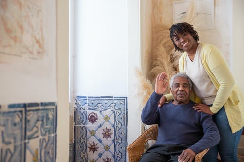 蓝色长袖衬衫坐在棕色扶手椅上的女人 · 免费素材图片