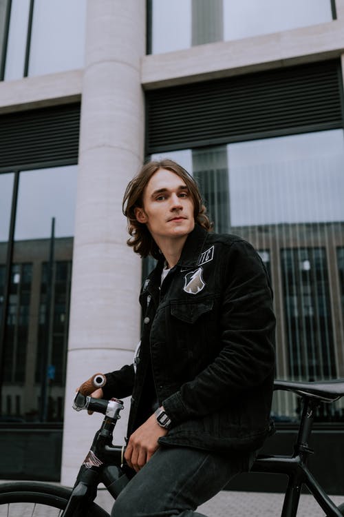 拿着白色和黑色照相机的黑夹克的妇女 · 免费素材图片