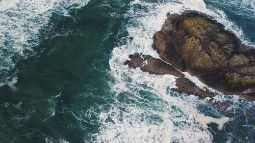 海浪在一块大岩石上撞击 · 免费素材视频