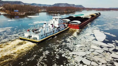 一艘驳船在冰山上航行 · 免费素材视频