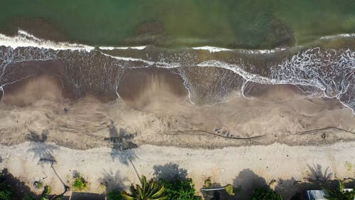 波浪的慢动作镜头，从上面研磨在沙滩上 · 免费素材视频
