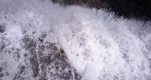 空中的瀑布迅速流下到岩石河床的航拍 · 免费素材视频