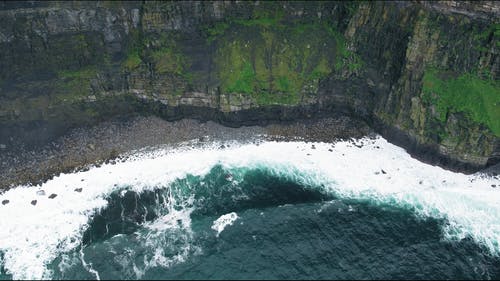 海浪在悬崖下面的海岸上破碎 · 免费素材视频
