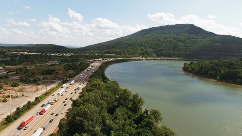 在河边的公路上行驶的车辆的鸟瞰图 · 免费素材视频