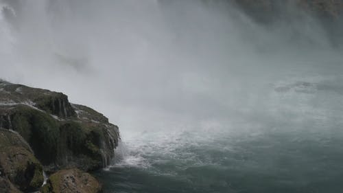 水瀑布落在河里的岩石上 · 免费素材视频