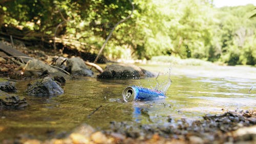 空锡罐漂浮在小河上的慢镜头 · 免费素材视频