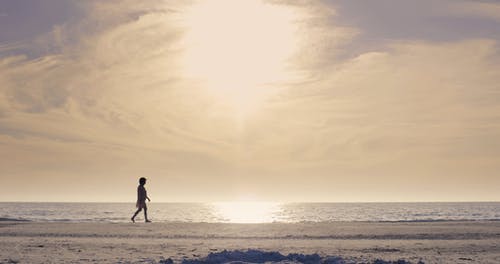 沿着海滩散步的女人的低角度镜头 · 免费素材视频