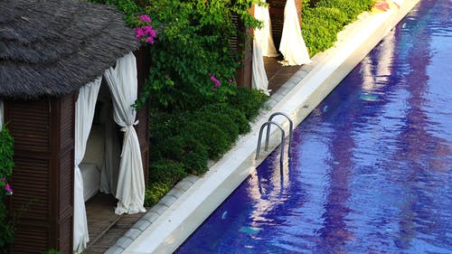 在带小屋的游泳池里游泳的女人 · 免费素材视频