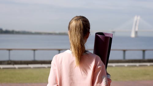 瑜伽垫在海港附近行走的女人 · 免费素材视频