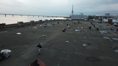 男子骑在屋顶上的滑板 · 免费素材视频