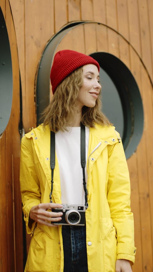 红色豆豆和黄色外套与相机的女人 · 免费素材视频