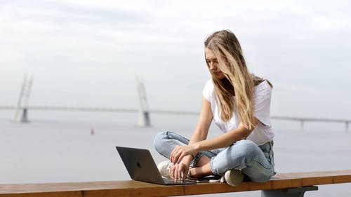 一个女人在户外使用她的笔记本电脑 · 免费素材视频