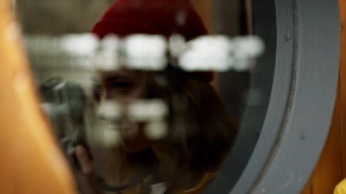 女人用反射在玻璃窗口上拍照 · 免费素材视频