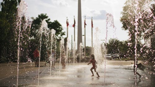 儿童和成人在喷泉玩耍的慢动作镜头 · 免费素材视频