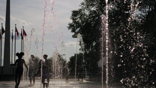 儿童和成人在喷泉玩耍的慢动作镜头 · 免费素材视频