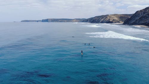 冲浪者划过海与山的风景鸟瞰图 · 免费素材视频