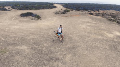 一个骑自行车的人在高原上俯瞰大海 · 免费素材视频