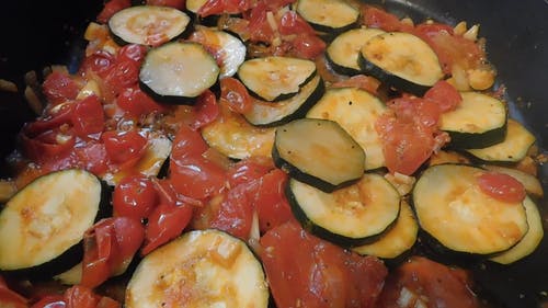 切成薄片的西红柿西葫芦，在煎锅里嘶嘶作响的特写镜头 · 免费素材视频