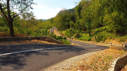 在漫长而曲折的道路上超速驾驶的摩托车手 · 免费素材视频