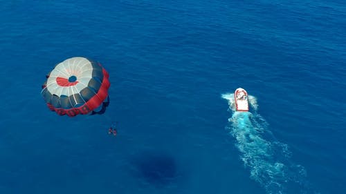一对夫妇在大海的蓝色水中滑翔伞 · 免费素材视频