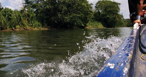 从一艘正在移动的小船在河上飞溅的水的慢动作镜头 · 免费素材视频