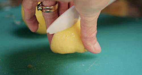 一个人在慢动作在砧板上切柠檬的特写镜头 · 免费素材视频