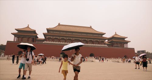 人们的慢动作镜头主要是在雨伞走在寺庙的外围周围 · 免费素材视频