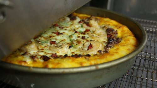 从自动烤箱出来的新鲜出炉的比萨的特写 · 免费素材视频