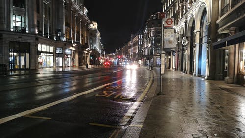 毛毛雨的夜晚在城市街道上的车辆交通的低角度镜头 · 免费素材视频