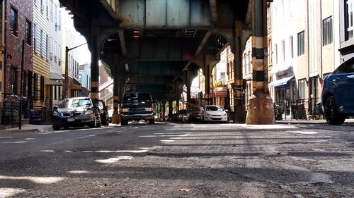 在桥下的城市街道上占用停车位的车辆 · 免费素材视频
