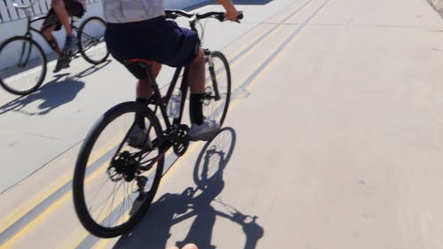 骑自行车的人和慢跑者在限制行车线 · 免费素材视频
