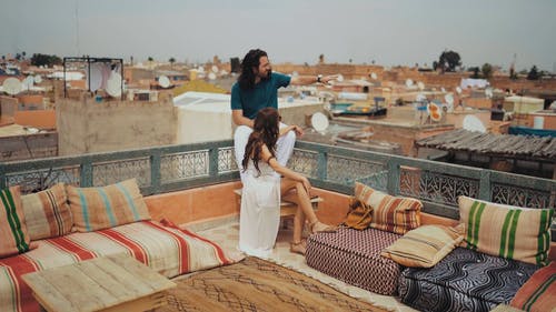 男人和女人坐在屋顶上，周围的景色 · 免费素材视频