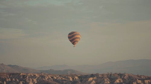 热气球飞越沙漠山丘 · 免费素材视频