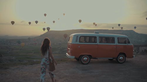 热气球在空中和骑着她的车的女人的视图 · 免费素材视频