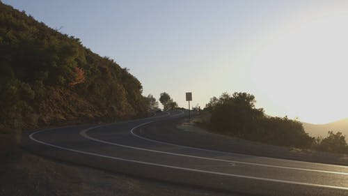一辆敞篷汽车通过山坡上的道路弯道 · 免费素材视频
