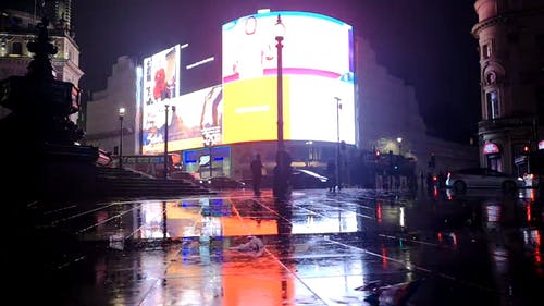 建筑物上的巨型电子广告牌在夜间显示品牌广告 · 免费素材视频
