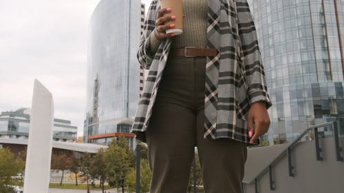 建筑物外面的一名常设妇女在一杯咖啡喝 · 免费素材视频