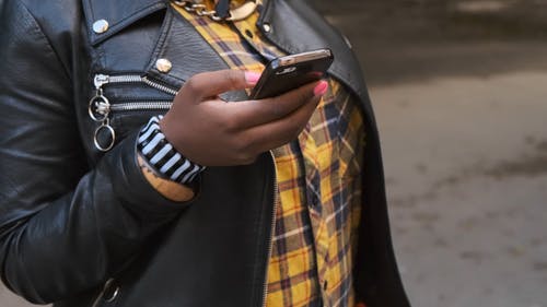 一个女人在树林里用她的手机 · 免费素材视频