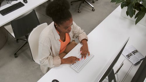 在现代办公空间中的台式计算机上工作的一个女人的顶视图 · 免费素材视频