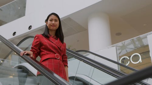 一个微笑的女人骑着自动扶梯下去 · 免费素材视频