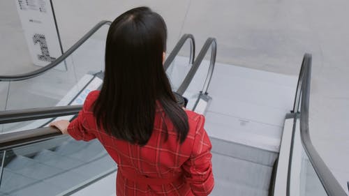 自动扶梯上的一个女人转过身微笑 · 免费素材视频