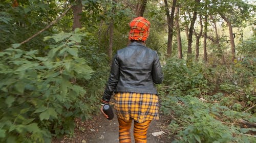 一个女人在树林里散步的背面 · 免费素材视频